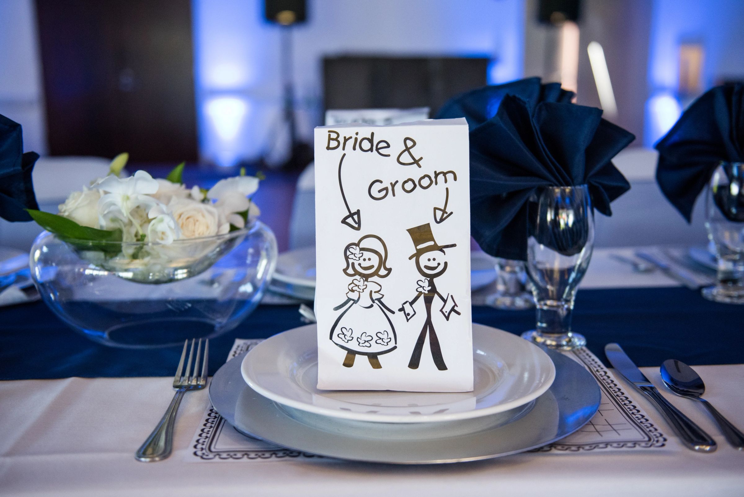 Bride and groom place card at a navy-dressed reception table