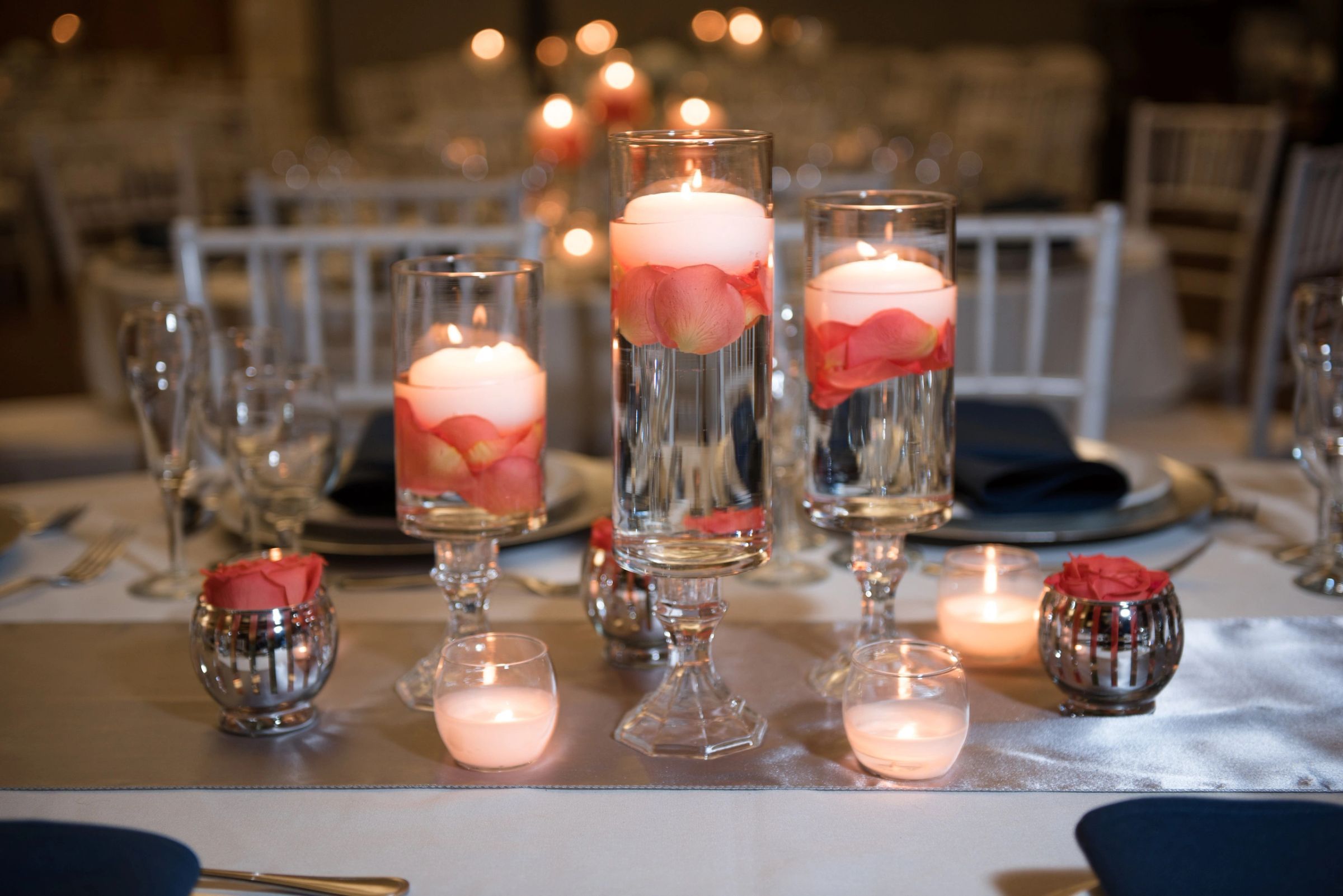 Floating candle centerpieces glowing on a reception table