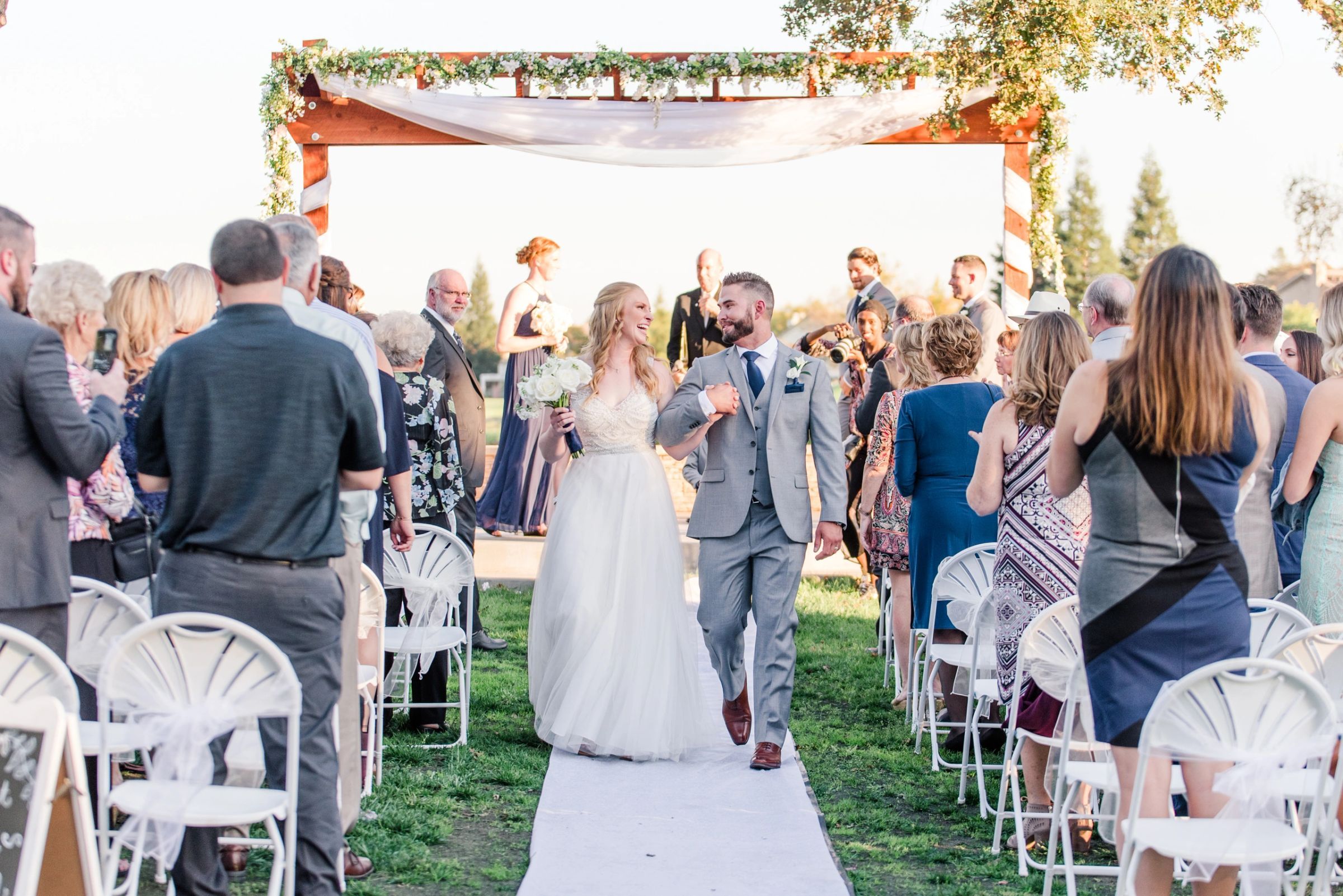 Newlyweds walking back down the aisle past cheering guests