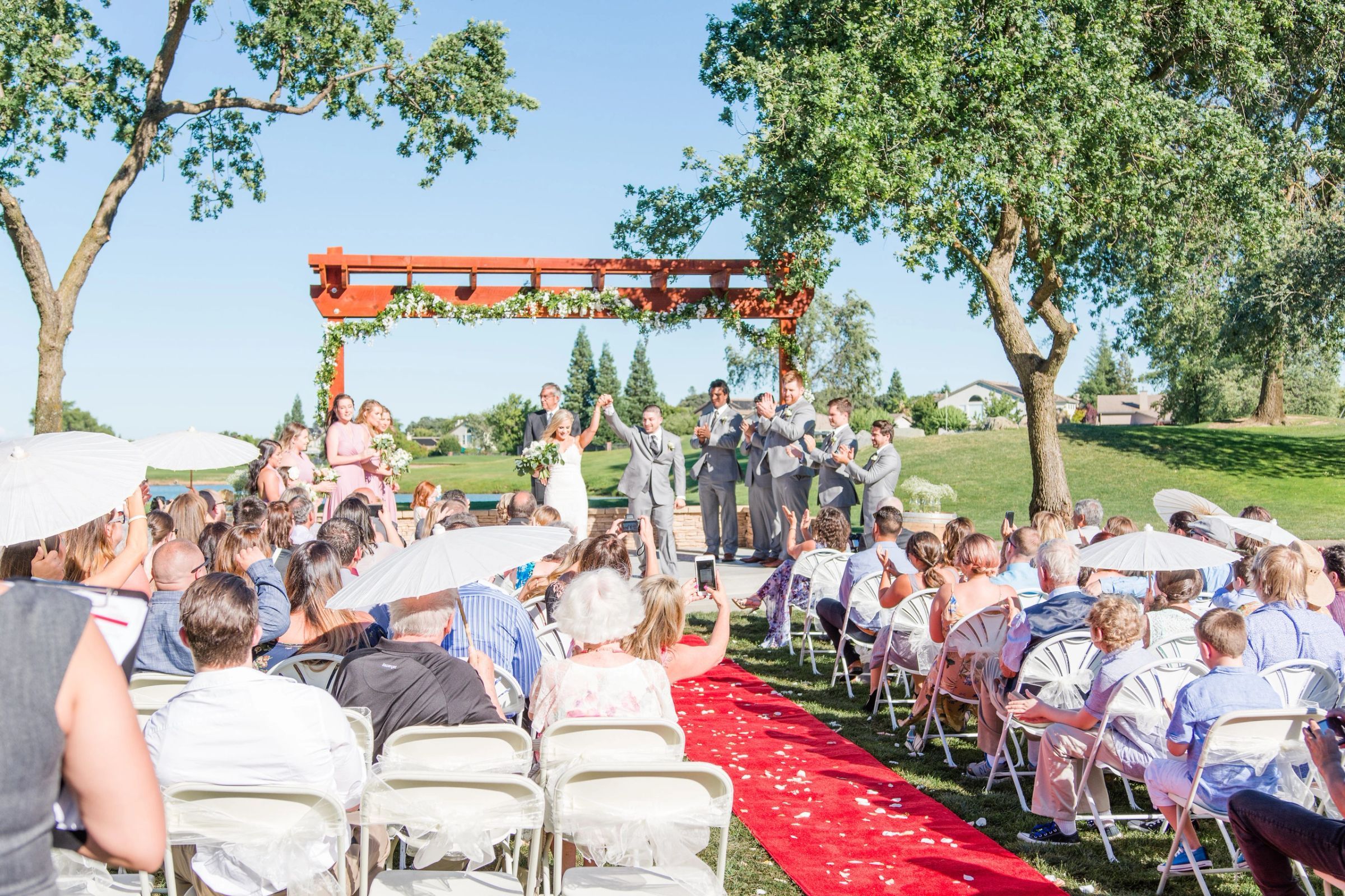 An outdoor wedding ceremony on the lawn beneath the oaks at The Clubhouse at Woodcreek