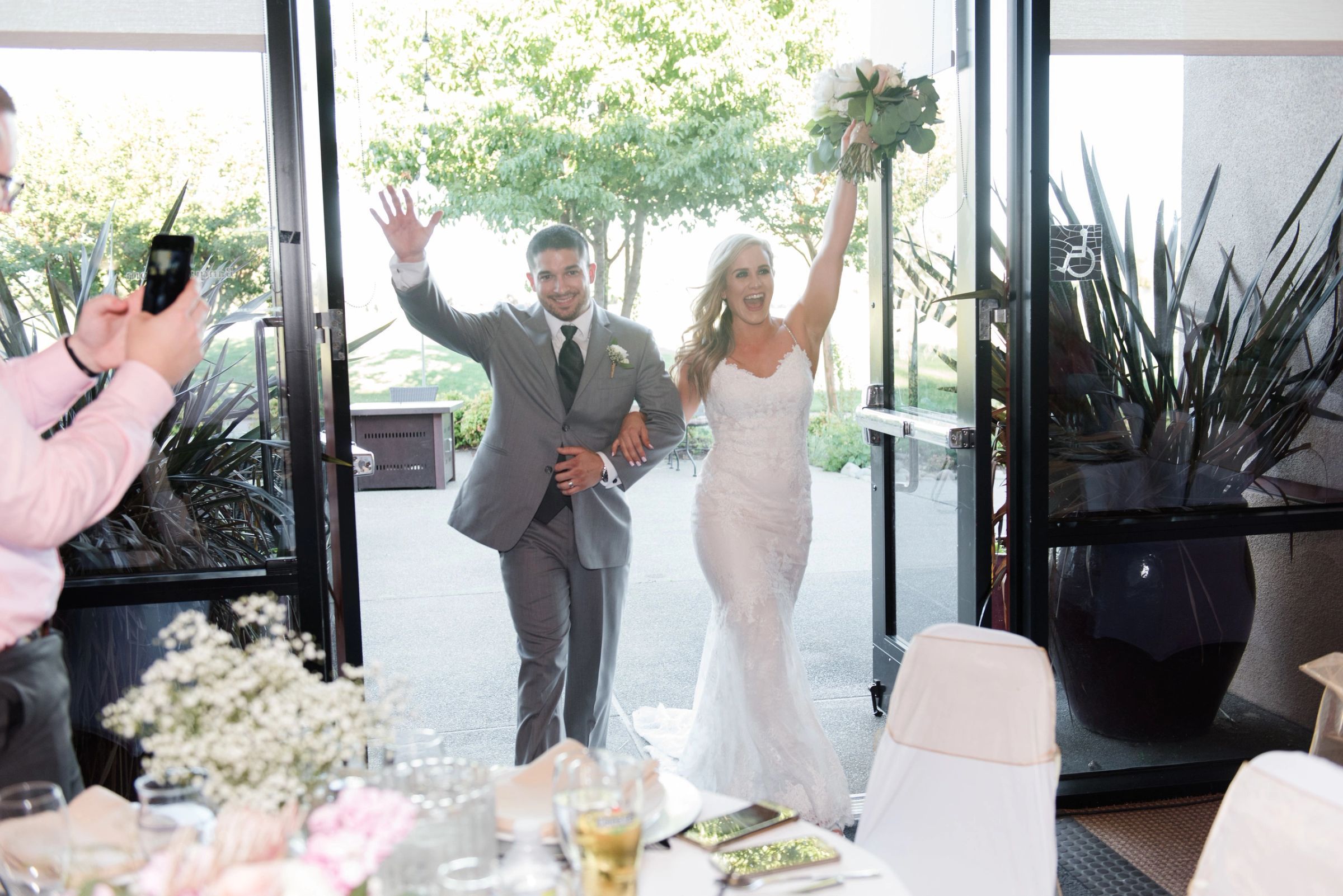 A bride and groom entering their reception