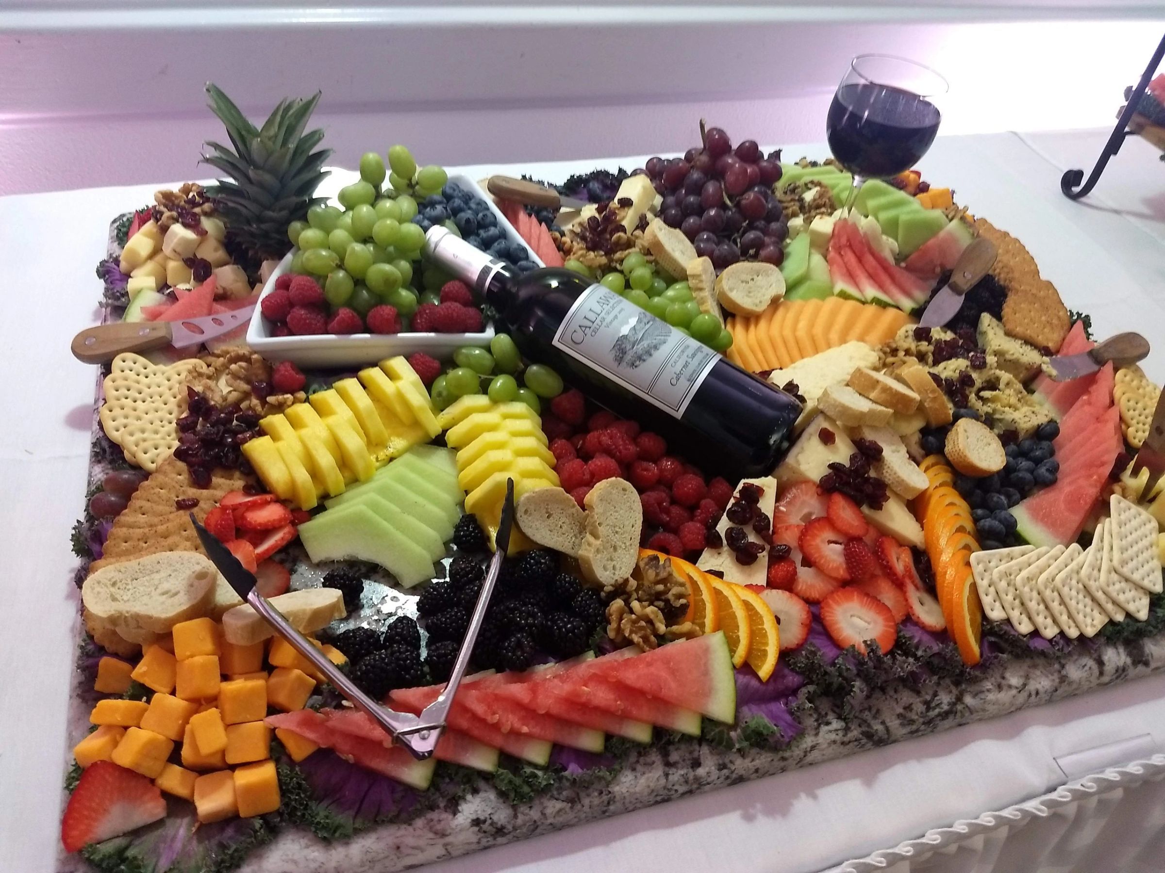 A grazing board of fruit, cheese, charcuterie and wine