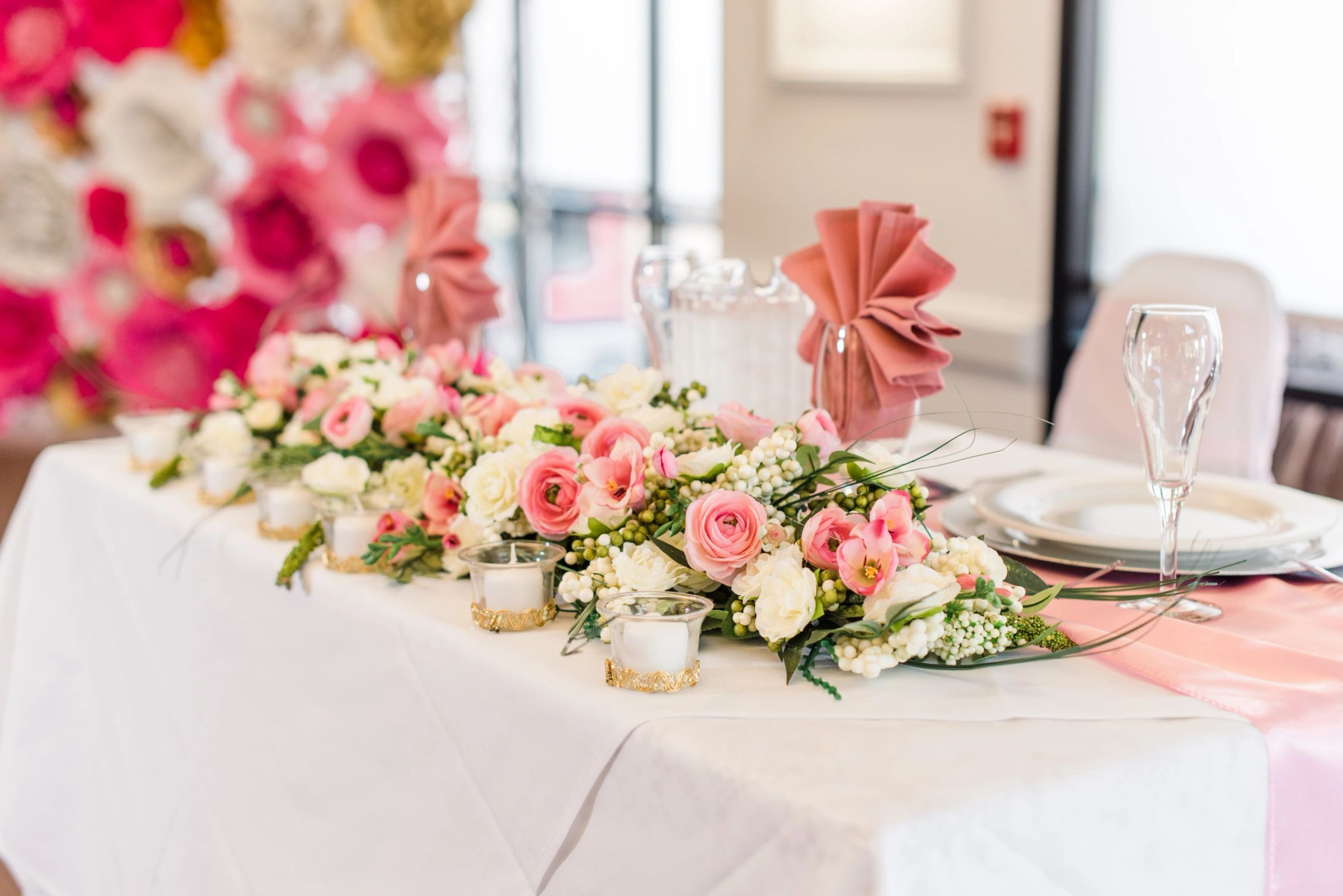 Head table dressed with pink and white roses and gold chargers