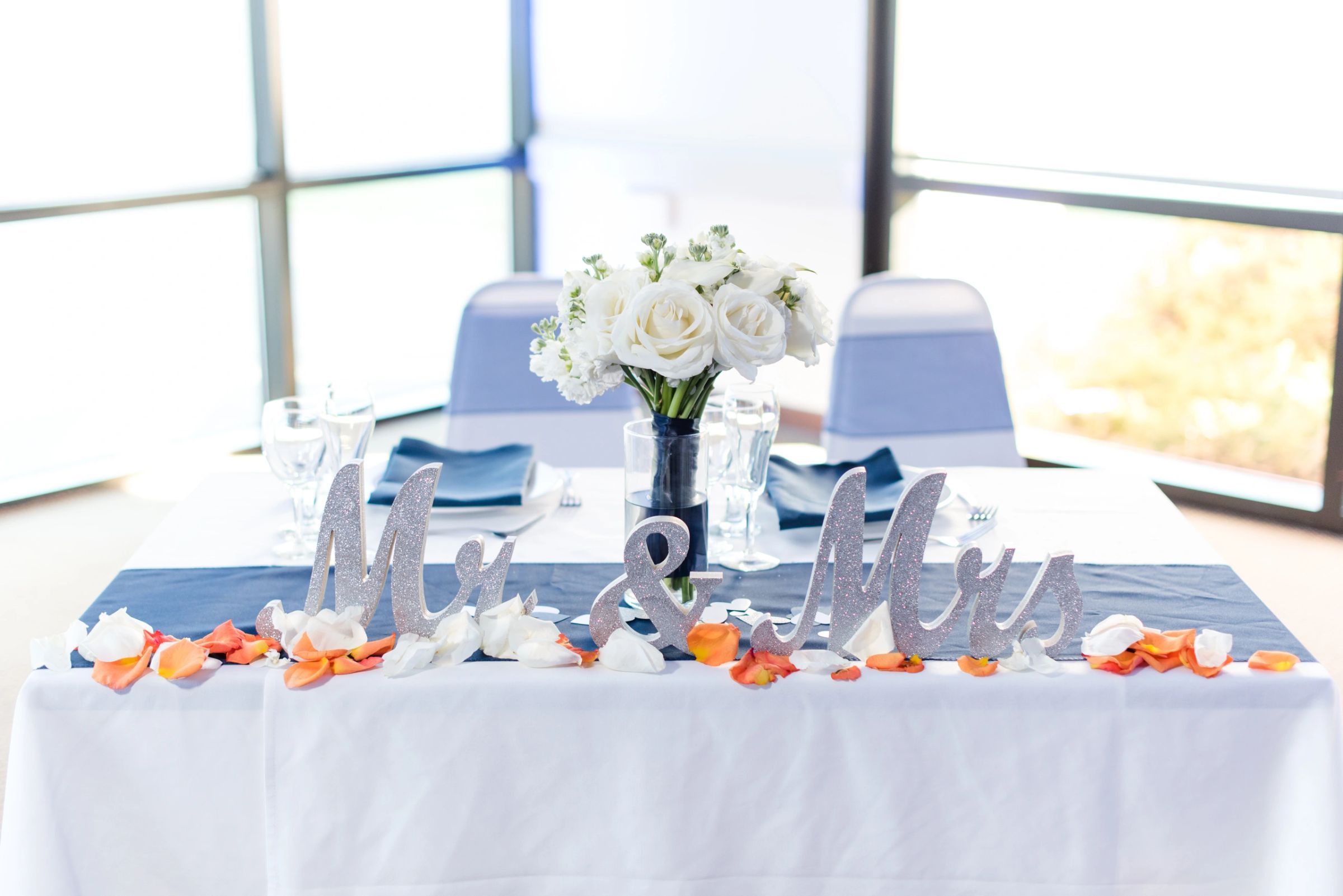 Mr & Mrs sweetheart table with white florals and blush petals