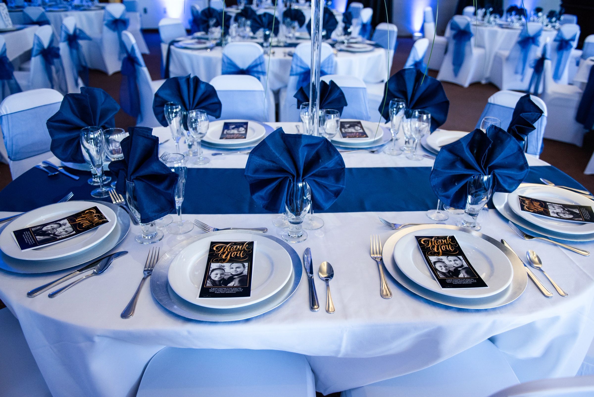 Navy and white place settings with menu cards at a reception table
