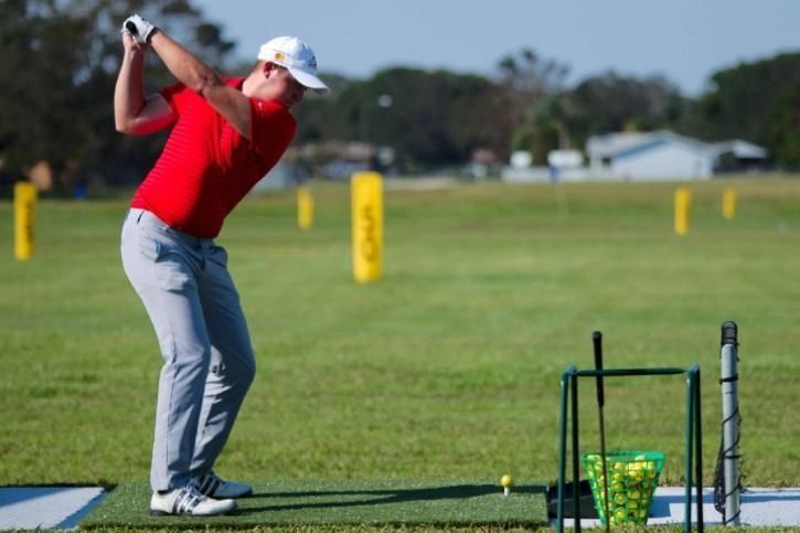 A golfer working through the bag on the practice range